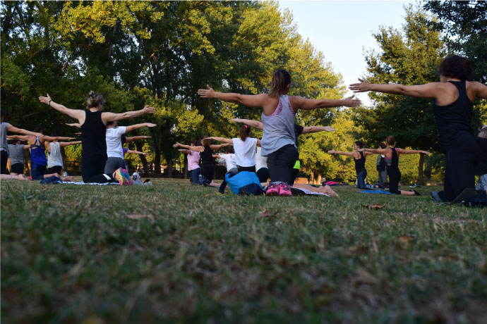 Women's fitness yoga class outdoors on the grass