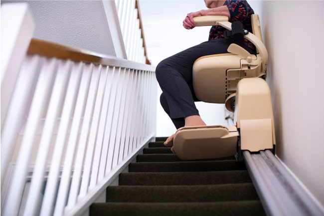 Elderly woman sitting on stair lift chair