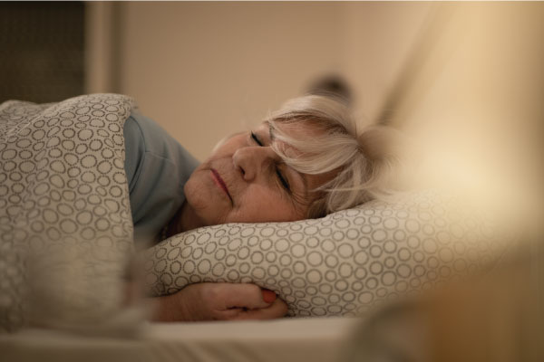 Senior-woman-sleeping-on-bed-at-night