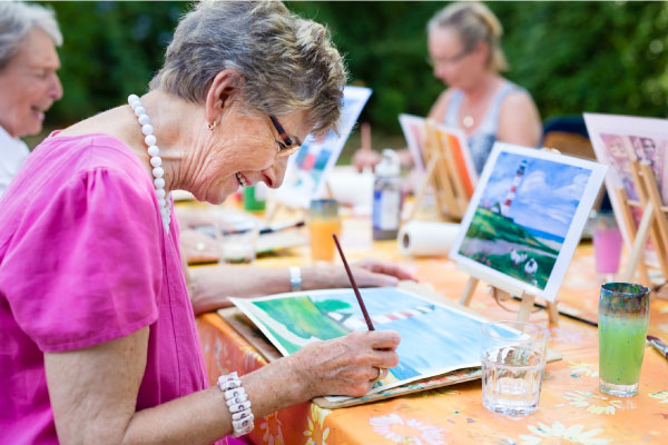 Senior-woman-smiling-while-drawing-with-the-group